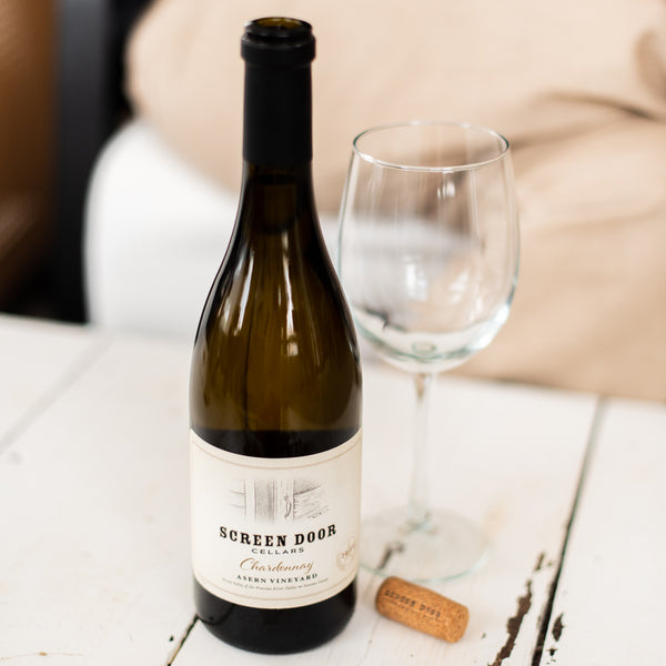 A bottle of Screen Door Chardonnay with a wine glass.