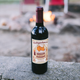 A bottle of Badgerhound Red Blend in front of a cozy fire.